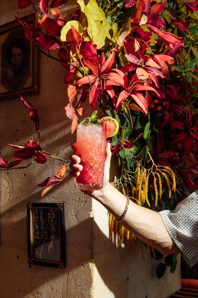 Cocktail rouge devant un mur végétal